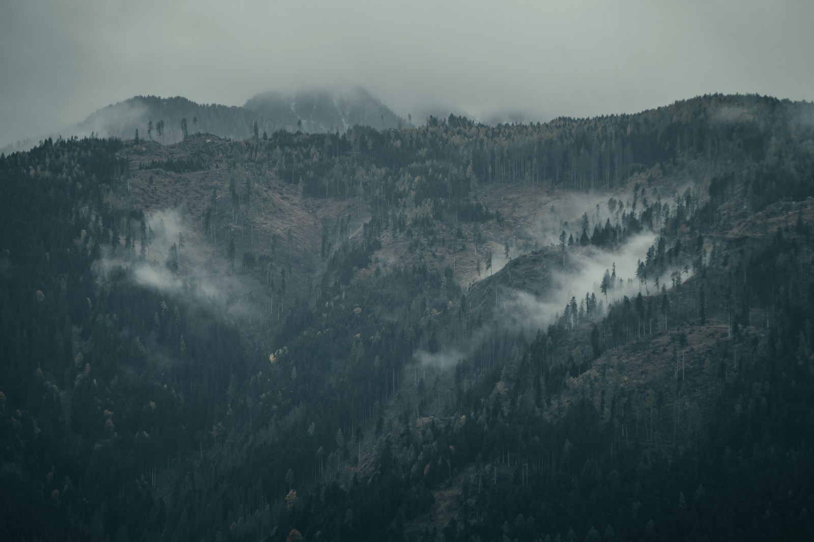 a mountain covered in fog and low lying clouds