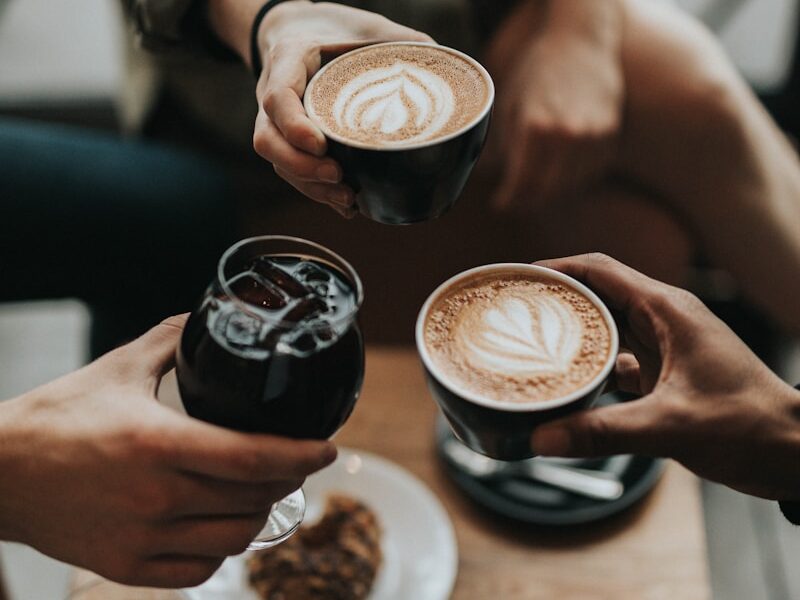 three person holding mug and glass with beverage inside